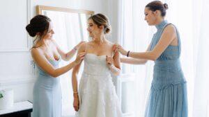 Deux jeunes filles habillant une jeune dame